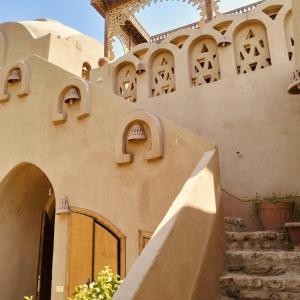 a building with a gate and stairs in front at Harmony Villas Sleeps 4 with Garden in Al Qurnah