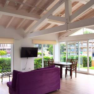 a living room with a purple couch and a table at Playa Joyel Family Surf House in Noja