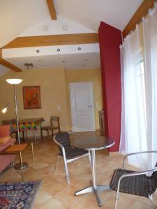 TOP Ferienwohnung Limburg "Am Bildstock" في Offheim: غرفة معيشة مع طاولة وكراسي في غرفة