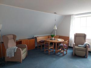 a waiting room with a table and chairs at Friesenrose Süd in Spiekeroog
