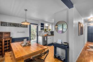 a kitchen and dining room with a wooden table at BEkiND Cottage in Bend