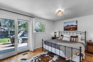 a bedroom with a bed and a sliding glass door at BEkiND Cottage in Bend