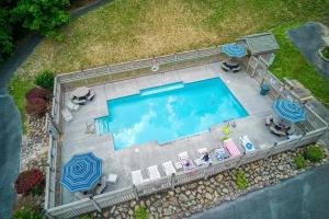 an overhead view of a swimming pool with chairs and umbrellas at Stairway To Heaven By Beyond Expectations in Sevierville
