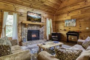 a living room with a fireplace and a piano at Stairway To Heaven By Beyond Expectations in Sevierville