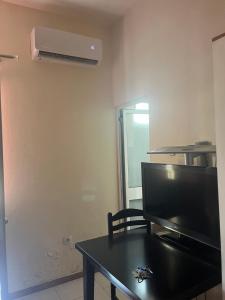 a living room with a black table and a tv at Hotel Luli City Center in Durrës +4 photos