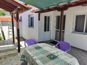 a patio with a table and purple chairs at ilkay's House in Makri