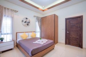 sypialnia z łóżkiem i drewnianą szafką w obiekcie My Sugar Pool Villa Na Jomtien w mieście Jomtien Beach