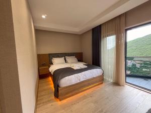a bedroom with a bed and a large window at Ladur Resort Otel in Trabzon