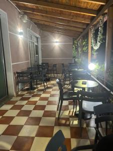 a restaurant with tables and chairs on a checkered floor at Hotel Luli City Center in Durrës