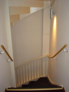 
a stairway leading up to a room with a white wall at Hotel Keistad in Amersfoort
