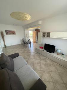 a living room with a couch and a tv at Lecasedialex it Casa thas in La Loggia