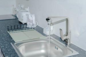 a kitchen sink with water coming out of a faucet at House Caparica in Costa da Caparica +39 photos