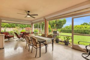 une salle à manger avec une table, des chaises et des fenêtres dans l'établissement 4 Miles to Beach and Walk to Shops, à Naples