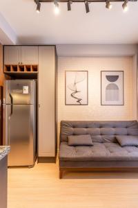 a living room with a couch and a refrigerator at Condomínio no Itaim, lindo Rooftop com vista para o Ibira!! in Sao Paulo