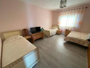 ein Schlafzimmer mit zwei Betten und einem Fernseher in der Unterkunft Mesi Bridge Villa in Shkodra