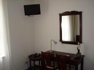 a room with a desk with a mirror and a table with chairs at Hotel Keistad in Amersfoort