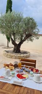 a table with food and a tree in the background at Les chambres de la Dombes in Pizay