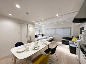a kitchen and living room with a white table and chairs at F Style Namiki by b hotel in Hiroshima