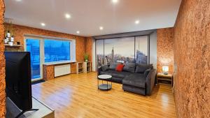 a living room with a couch and a tv at SunCity Apartment in Šiauliai