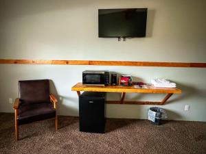 a desk with a microwave and a chair in a room at Whitecap Mountains Resort in Upson