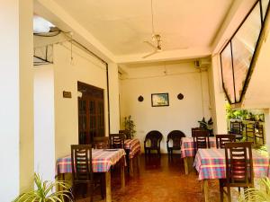 a dining room with tables and chairs in a room at Deshan Homestay & Restaurant in Tangalle
