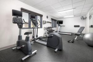 a gym with several tread machines and a simulator at Country Inn & Suites by Radisson, Big Flats (Elmira), NY in Horseheads