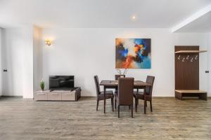a dining room with a table and chairs and a tv at Alpine Escape Studio - Silver Mountain Resort & SPA - Poiana Brasov in Poiana Brasov