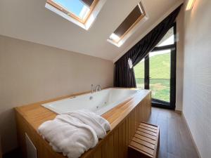 a bathroom with a large bath tub with a window at Ladur Resort Otel in Trabzon