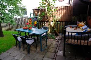 a patio with a blue table and chairs in a backyard at Chill house in Palanga