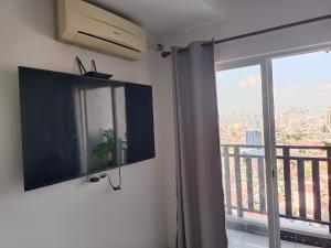 Un televisor de pantalla plana en una pared junto a una ventana. en L Residence-Near Russian market and Chip mong 271, en Phnom Penh 1 foto más