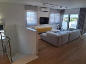 a living room with a couch and a tv at Apartman Plesa in Povljana