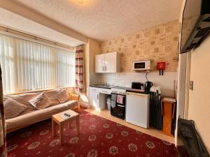 a small living room with a couch and a kitchen at Fairhaven Holiday Flats in Blackpool