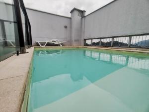 basen z błękitną wodą przed budynkiem w obiekcie Saint Sebastian ap115 -stúdio para casal w mieście Jaraguá do Sul