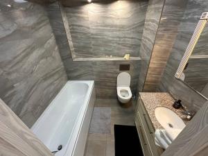 a bathroom with a tub and a toilet and a sink at AIRPORT HOTEL APARTAMENTS & TAXI ViP in Chişinău +16 photos