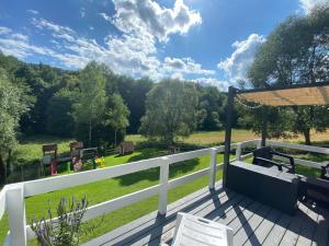 a deck with a view of a field and trees at Domki że Hej Bieszczady in Ustrzyki Dolne