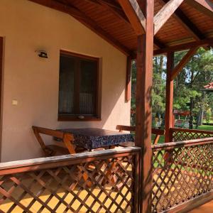 a porch of a house with a wooden railing at Viola Apartman in Zamárdi