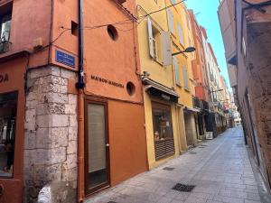 um beco estreito com edifícios numa cidade em T3 au Cœur de Perpignan - Castillet & Cathédrale - Wi-Fi em Perpignan