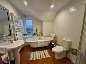 a bathroom with a tub and a toilet and a sink at Drumee Lodge boutique B and B, Newcastle, County Down in Newcastle +58 photos