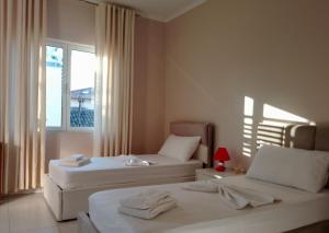 a hotel room with two beds and a window at Andrea House in Berat