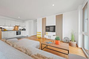 ein Wohnzimmer mit Sofa und Tisch in der Unterkunft Heimathafen mit See- & Bergsicht in Friedrichshafen