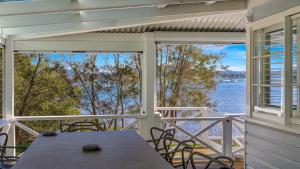 ein Tisch auf einer Veranda mit Blick auf das Wasser in der Unterkunft 'Yaringaa' by HolidayCo in Hardys Bay