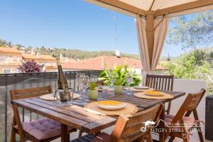 a wooden table with a bottle of wine on a patio at Beautiful Villa Encanto with private pool in Olivella