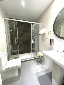 a bathroom with a shower and a toilet and a sink at Hostal Fernández Atocha in Madrid