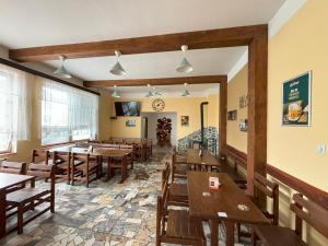 a restaurant with wooden tables and wooden chairs at Restaurace a penzion U Jezírka in Hřiměždice
