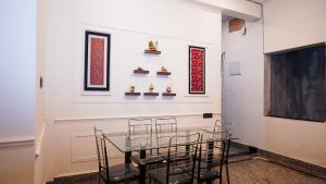 Un comedor con una mesa de cristal y sillas. en Mangalmay kashi Near kashi Vishwanath nd Ganga Ghat, en Varanasi
