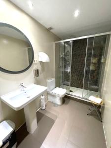 a bathroom with a sink and a toilet and a mirror at Hostal Fernández Atocha in Madrid +29 photos