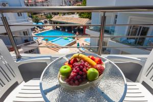 a bowl of fruit on a glass table on a balcony at Economisa Apartments in Ialyssos