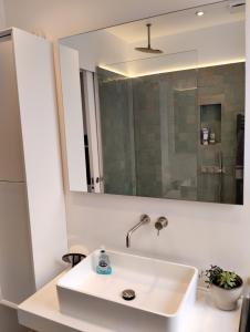 a bathroom with a white sink and a mirror at Cosy oasis with a view in London +33 photos