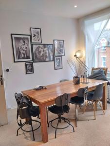 a dining room table with chairs and pictures on the wall at Cosy oasis with a view in London