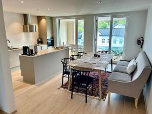 a kitchen and dining room with a table and chairs at Lekker Leilighet for 8 på Holmen-Kilsund Sjøfront in Arendal